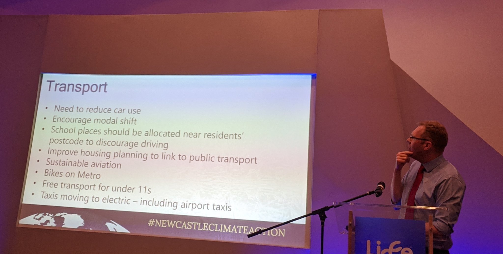 Picture of presentation slide titled transport with bullets: need to reduce car use, encourage mode shift, school places allocated near residents postcode, improve housing planning to link to public transport, sustainable aviation, bikes on Metro, free transport for under 11s, taxis moving to electric.