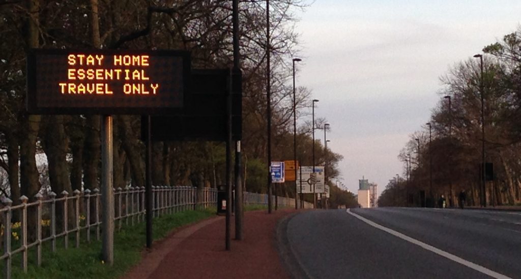 Electronic sign saying 'stay home essential travel only'