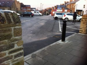  image of the wall and pedestrian entrance to car park with bollard in the middle of the path between the walls