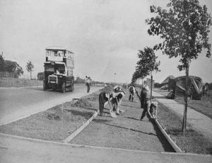 This picture shows workmen with spades working on a new 1930s cycle track in London: to the left is a bus on the road - image courtesy of Carlton Reid