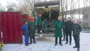 Asylum seekers with staff in front of a lorry with bikes