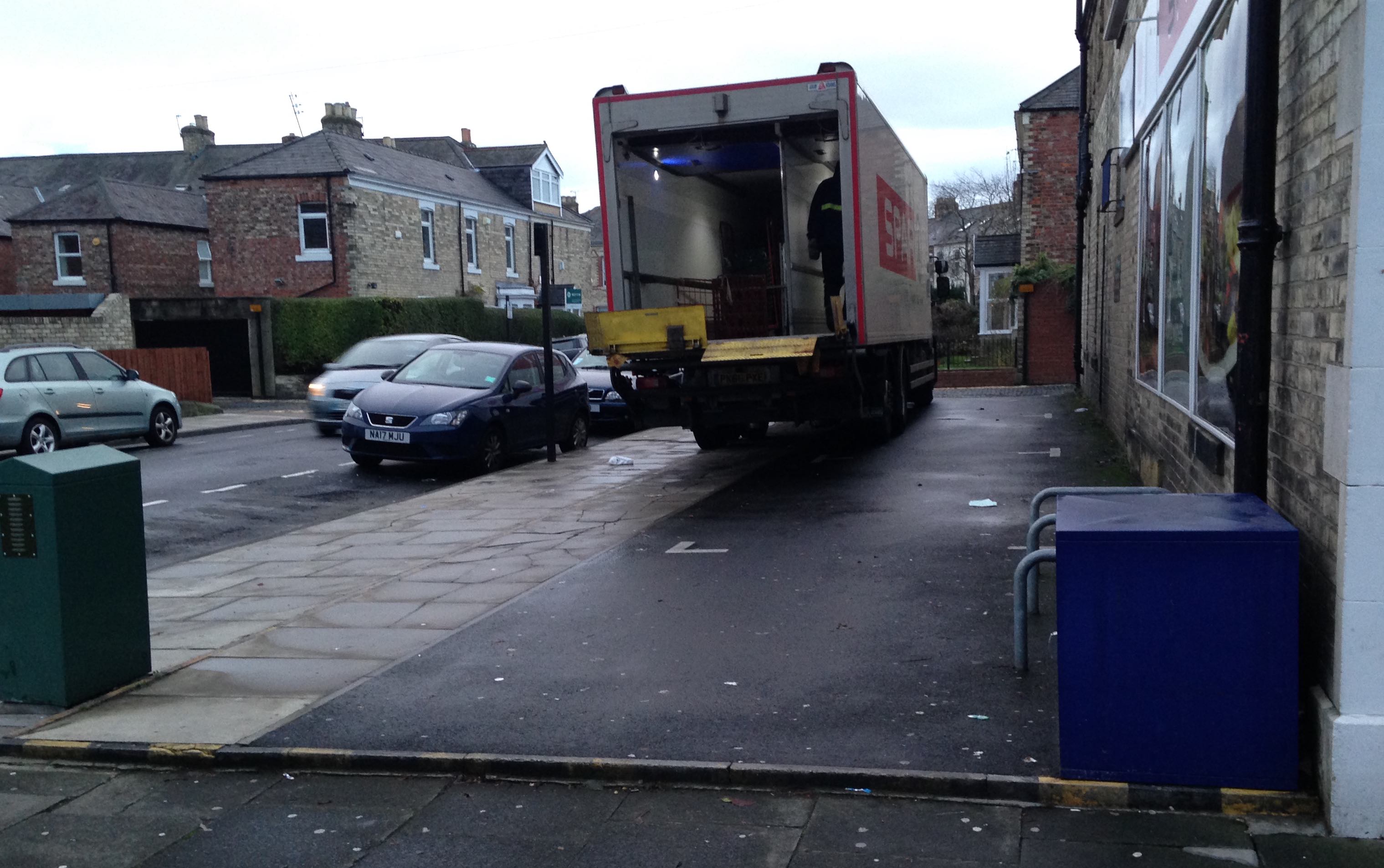 Delivery lorry parked on the parking space and pavement