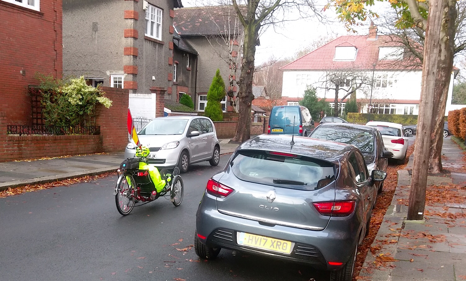 Photo of a recumbent cycle travelling between parked cars in West Gosforth.