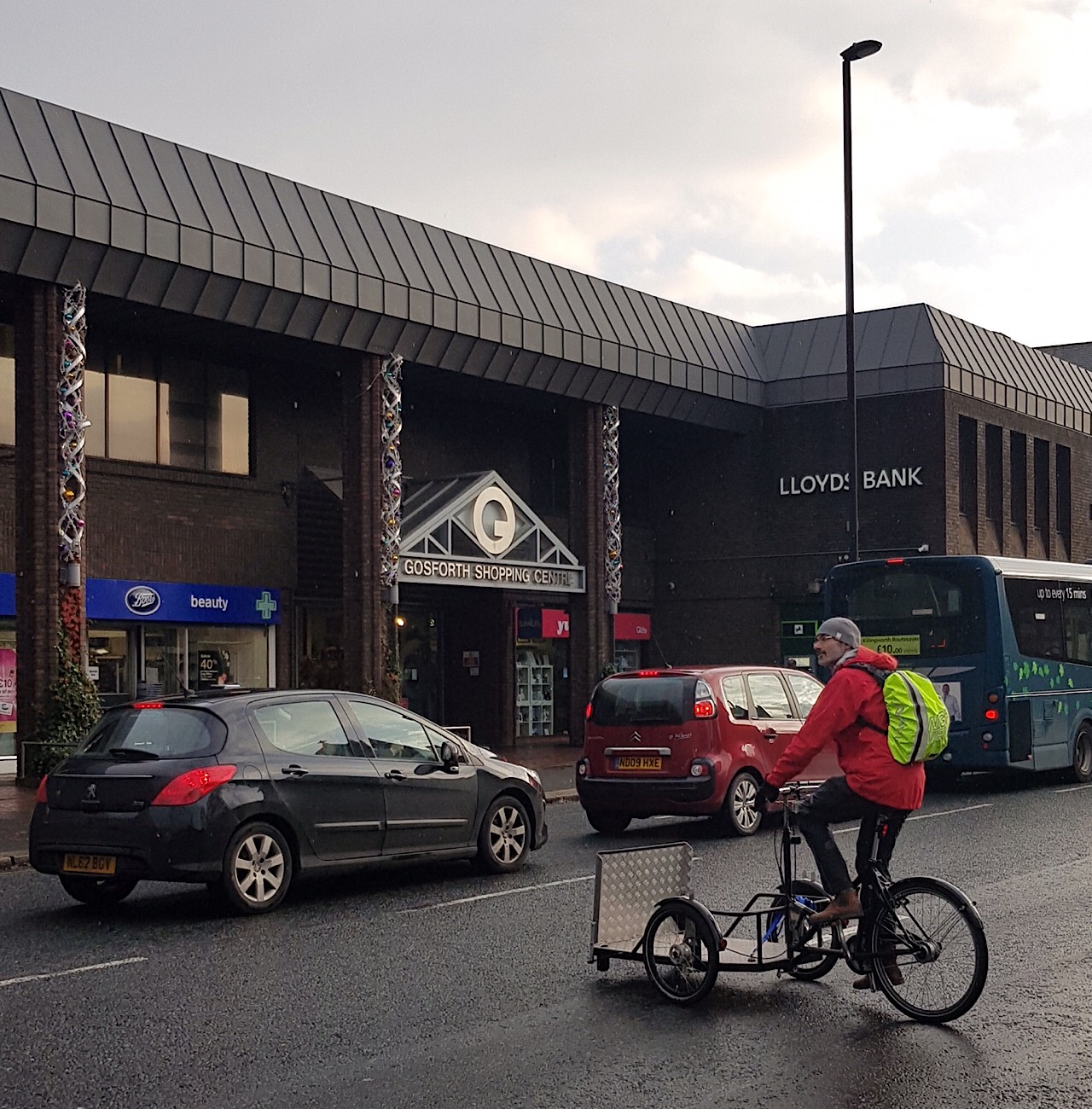 Picture of adapted cycle rider trying to cross traffic on Gosforth High Street.