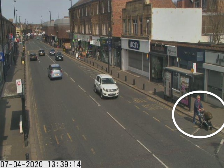 Traffic camera picture of Gosforth High Street with someone with a pram walking in the road.