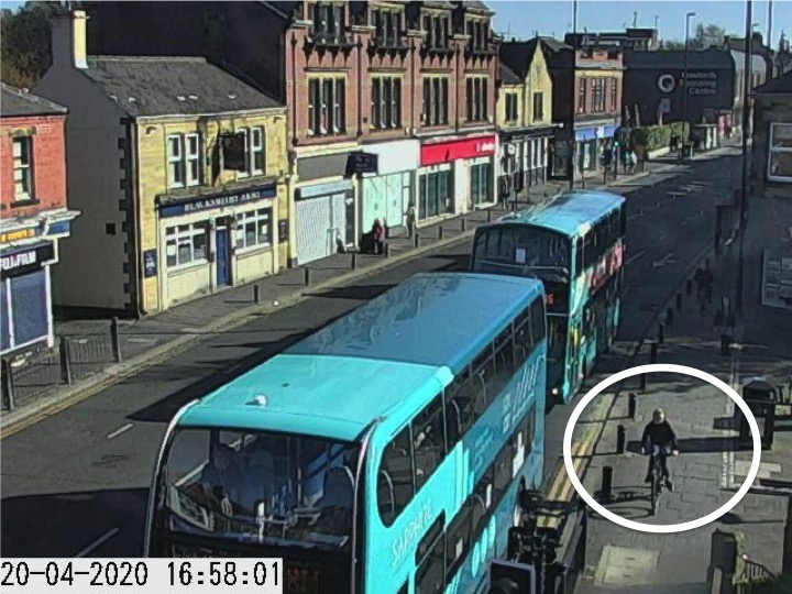 Traffic camera picture of Gosforth High Street with someone cycling on the pavement.