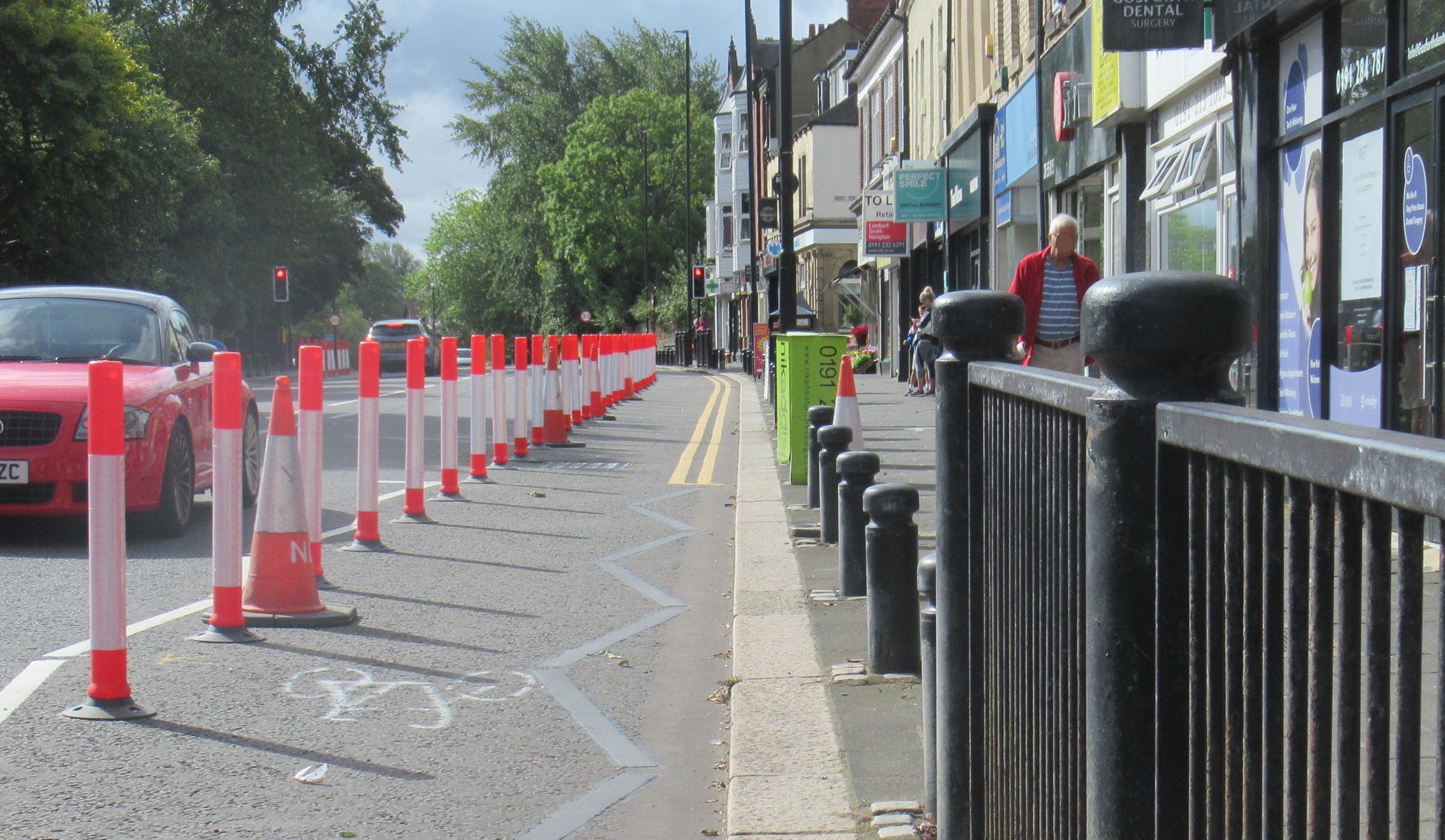 Cycle lane protected by poles west side of High Street south of The County