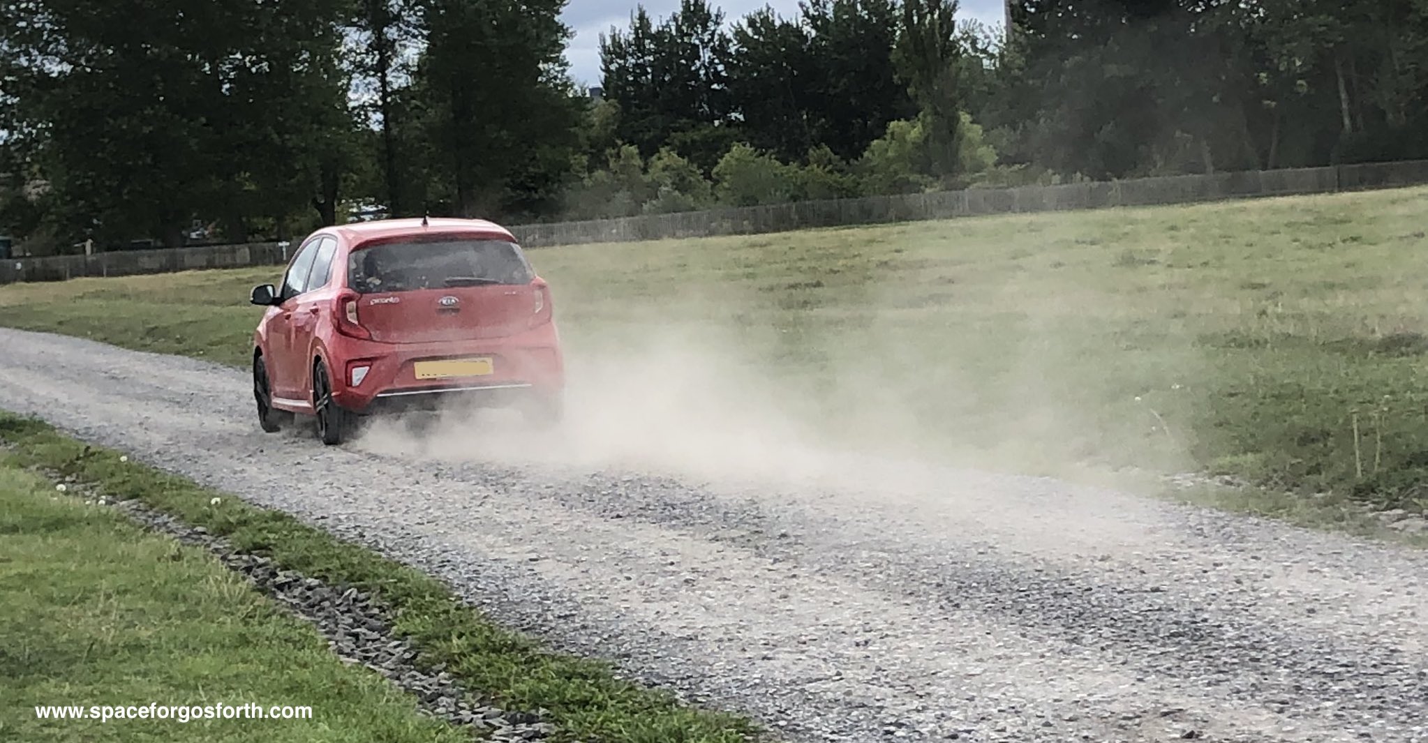 Car being driven on Town Moor gravel tracks with dust in the air