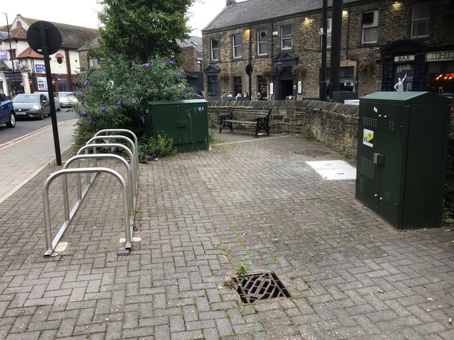 Picture of bike racks and a bench in the central island next to Gosforth Hotel