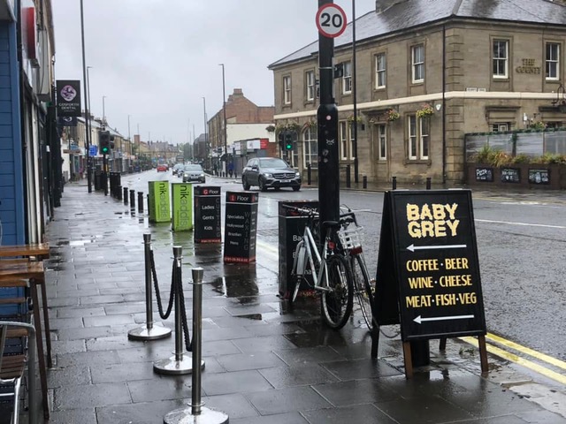 Picture of Gosforth High Street showing a pavement with cordoned off area for cafe seating