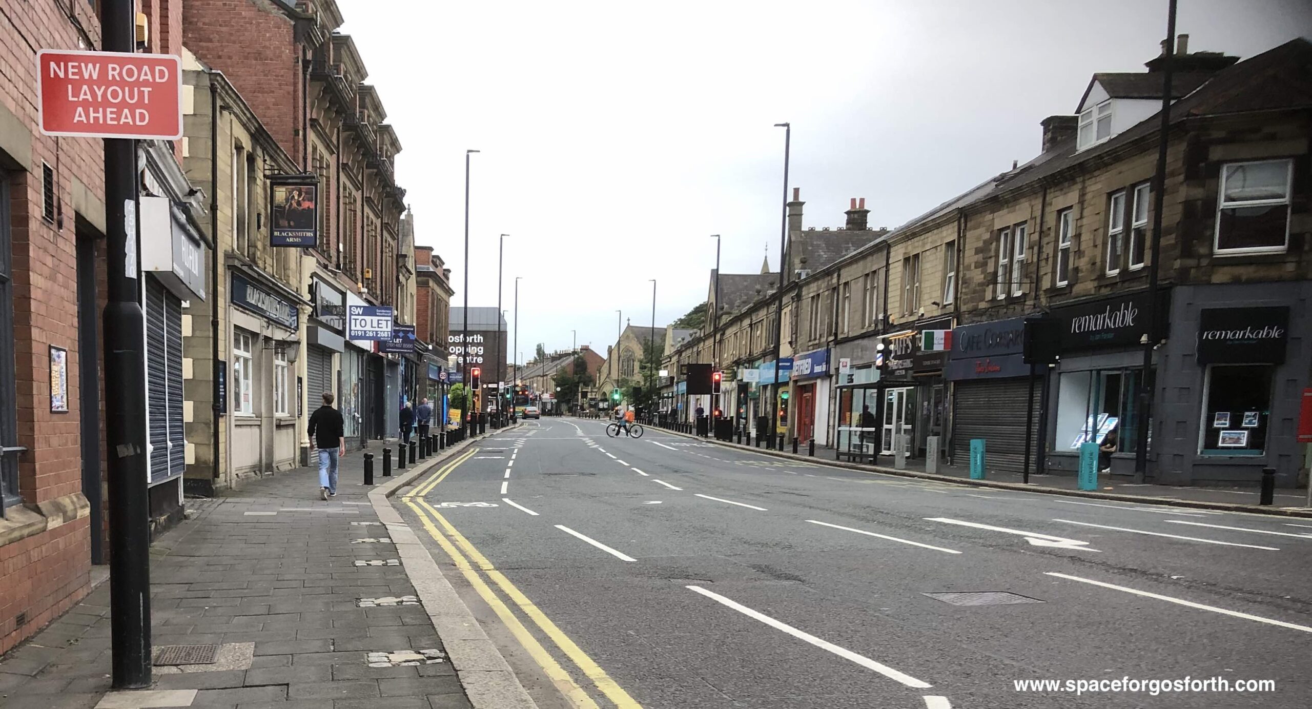 Picture of the north end of Gosforth HIgh Street, with a sign 'new road layout ahead'.